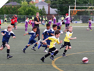 Young boys in jerseys playing an outdoor soccer match